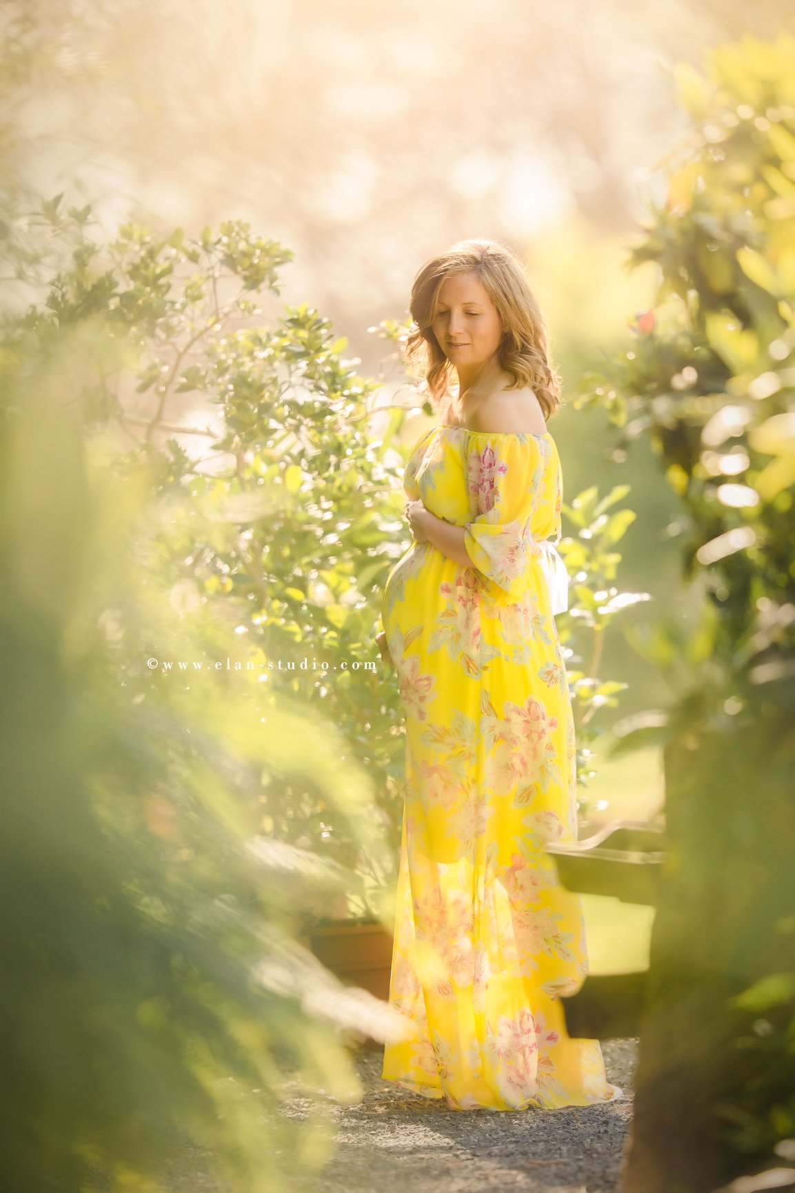 pregnant mother in yellow gown, in garden