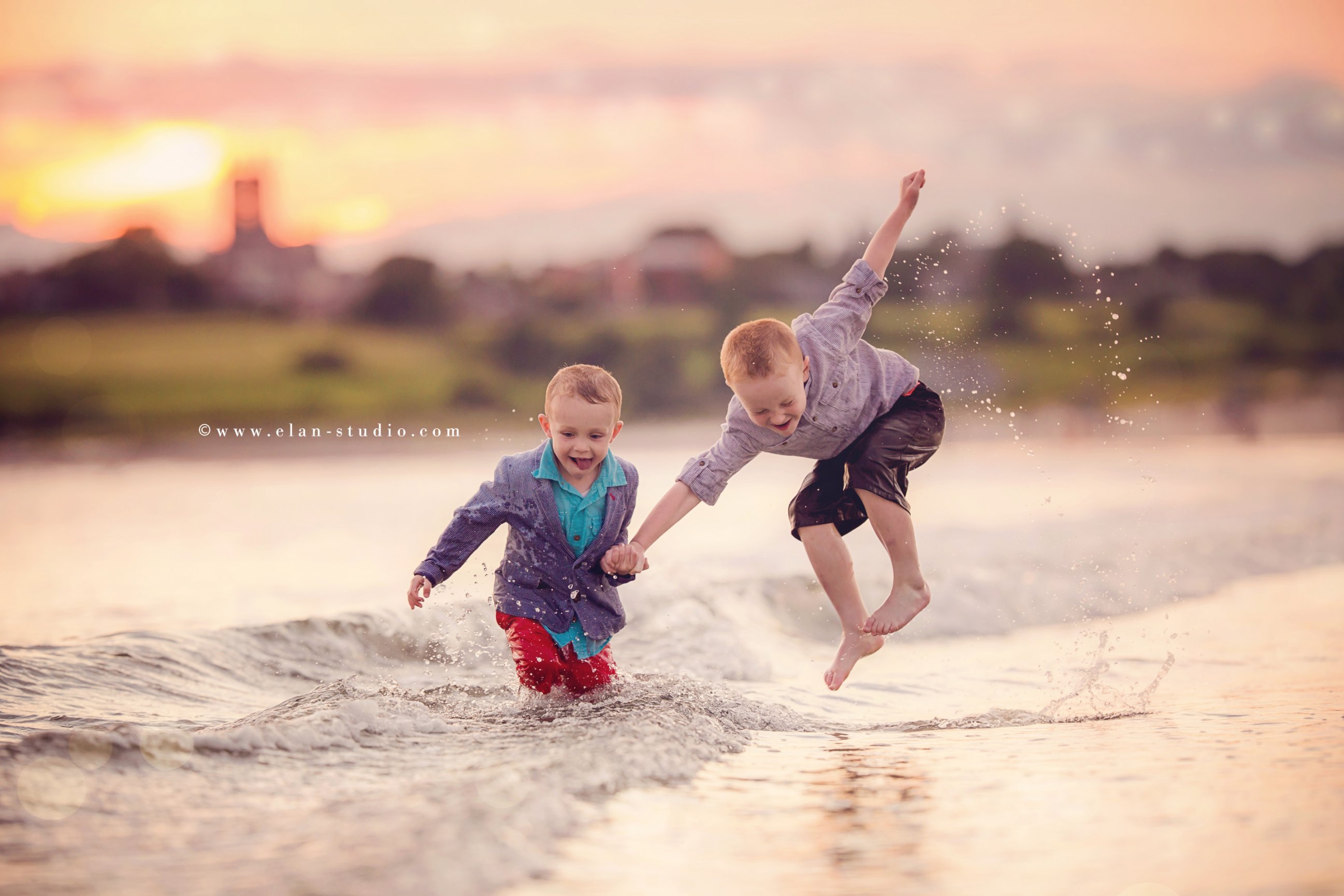 redheaded brothers playing in surf on beach