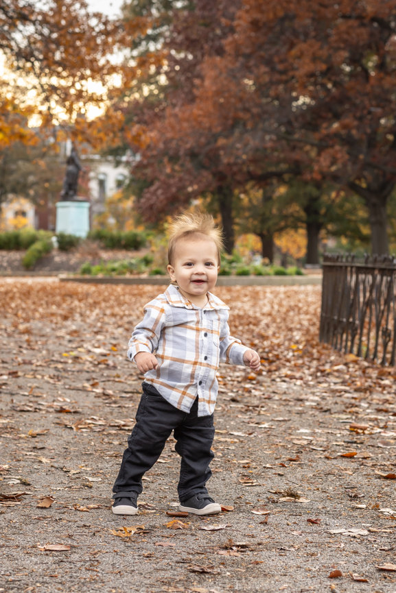 Toddler walking through leaves