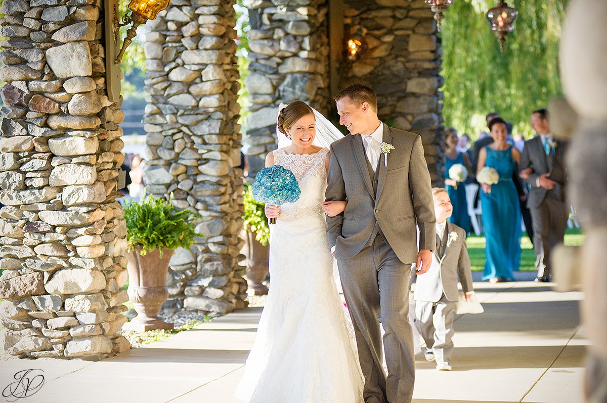 happy couple leaving ceremony as bride and groom