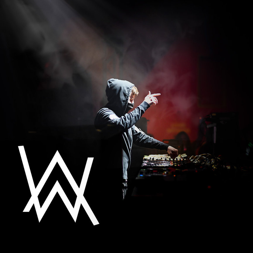 DJ performing live on stage with a hooded sweatshirt, surrounded by smoke and lighting effects.