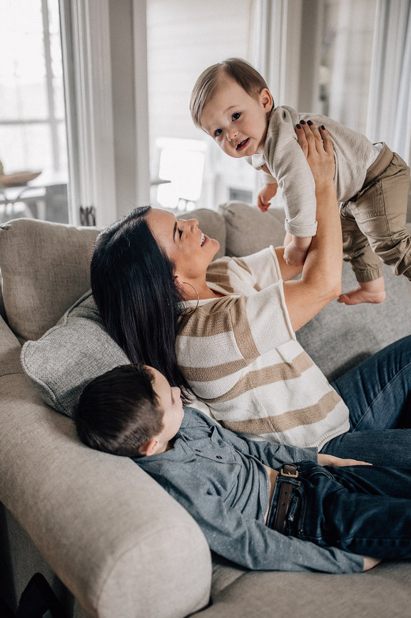 a mother lifts her young son into the air and smiles at him during a Huntsville Alabama family photoshoot