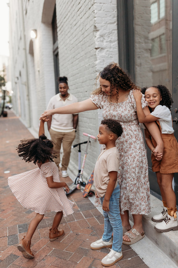 Huntsville Alabama family photoshoot Black mother spins daughter on city sidewalk