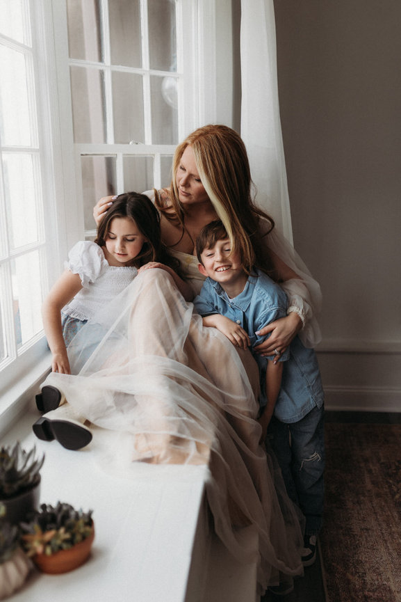 A mother sitting with her son and daughter in a window at a Mendham, New Jersey photography studio.