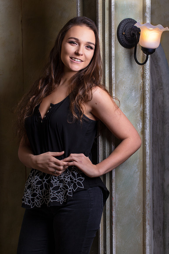 Indoor fine art portrait of a young woman with soft, sculpted studio lighting, highlighting natural expression, confidence, and elegant personality.