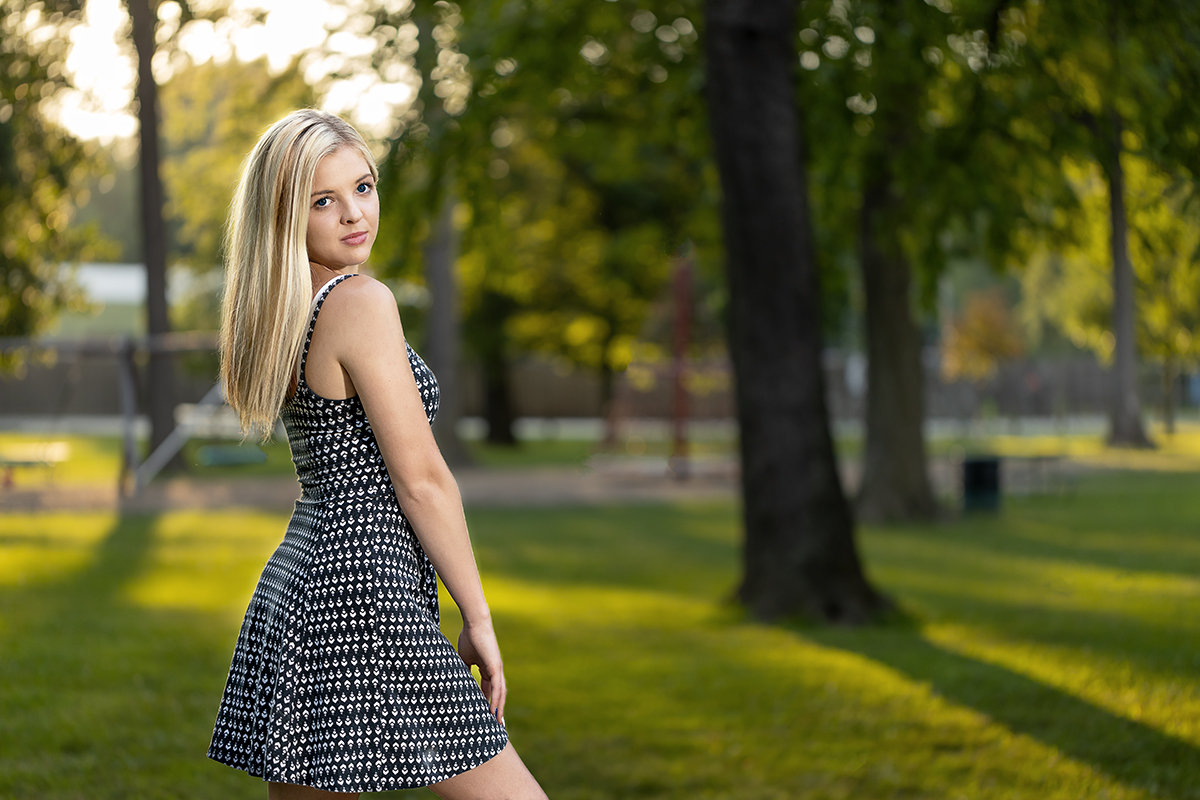 High school senior portrait of a young woman outdoors in Noblesville, Indiana, photographed in evening natural light with studio lighting on location for a warm and refined style