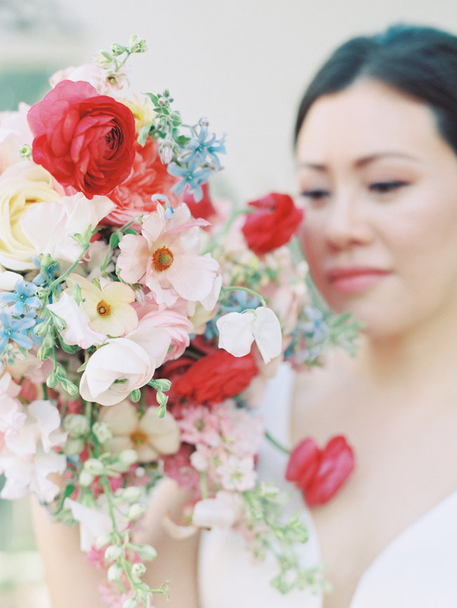 Dreamy bride holding her bouquet close to her face to showcase the pretiness of the flowers