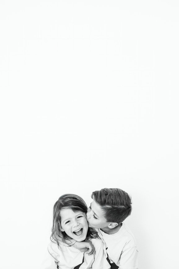 Clean and minimal portrait taken at a Portrait Studio Orange County of a boy holding his hands and framing his face