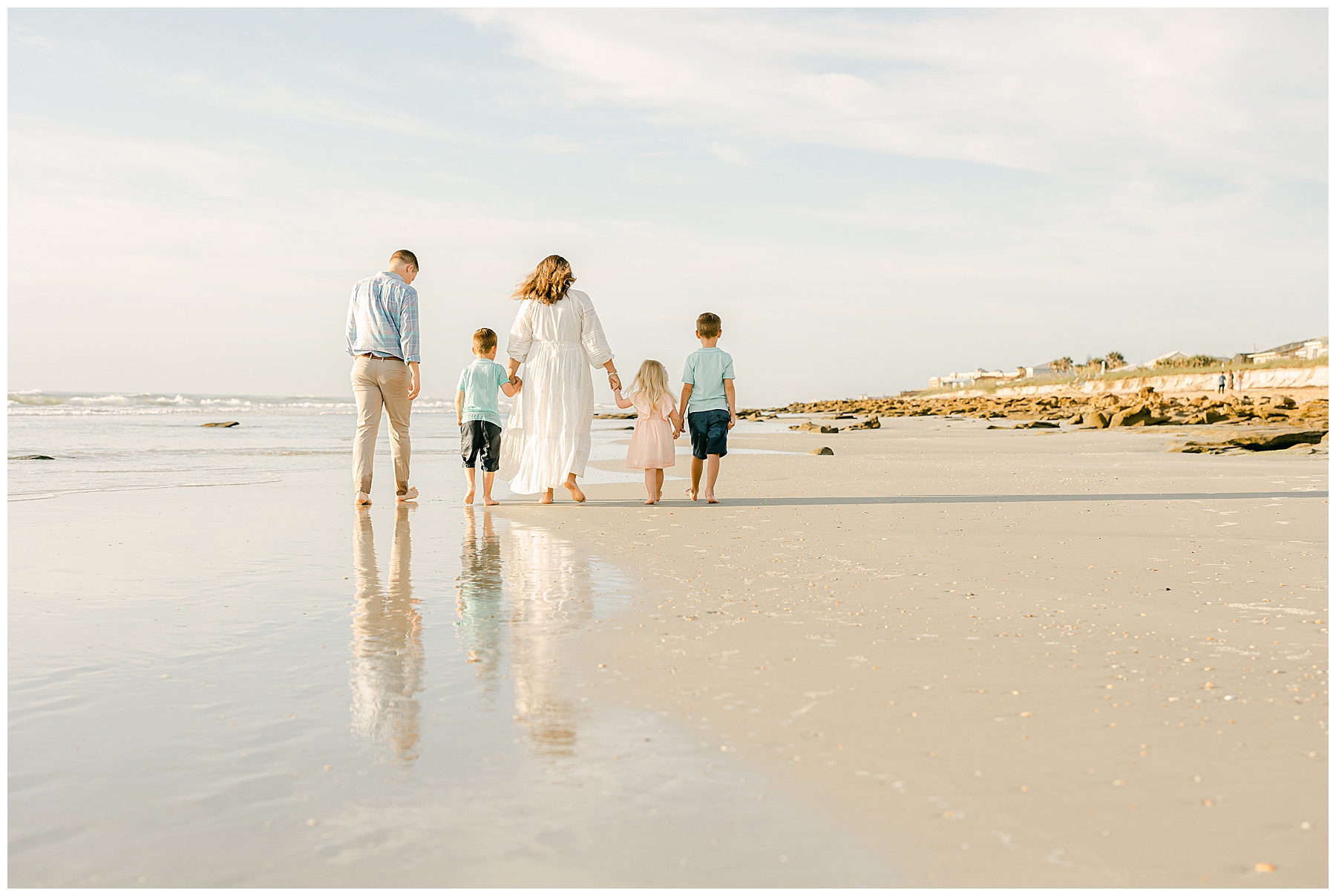 family walking on the beach at sunrise in Florida 