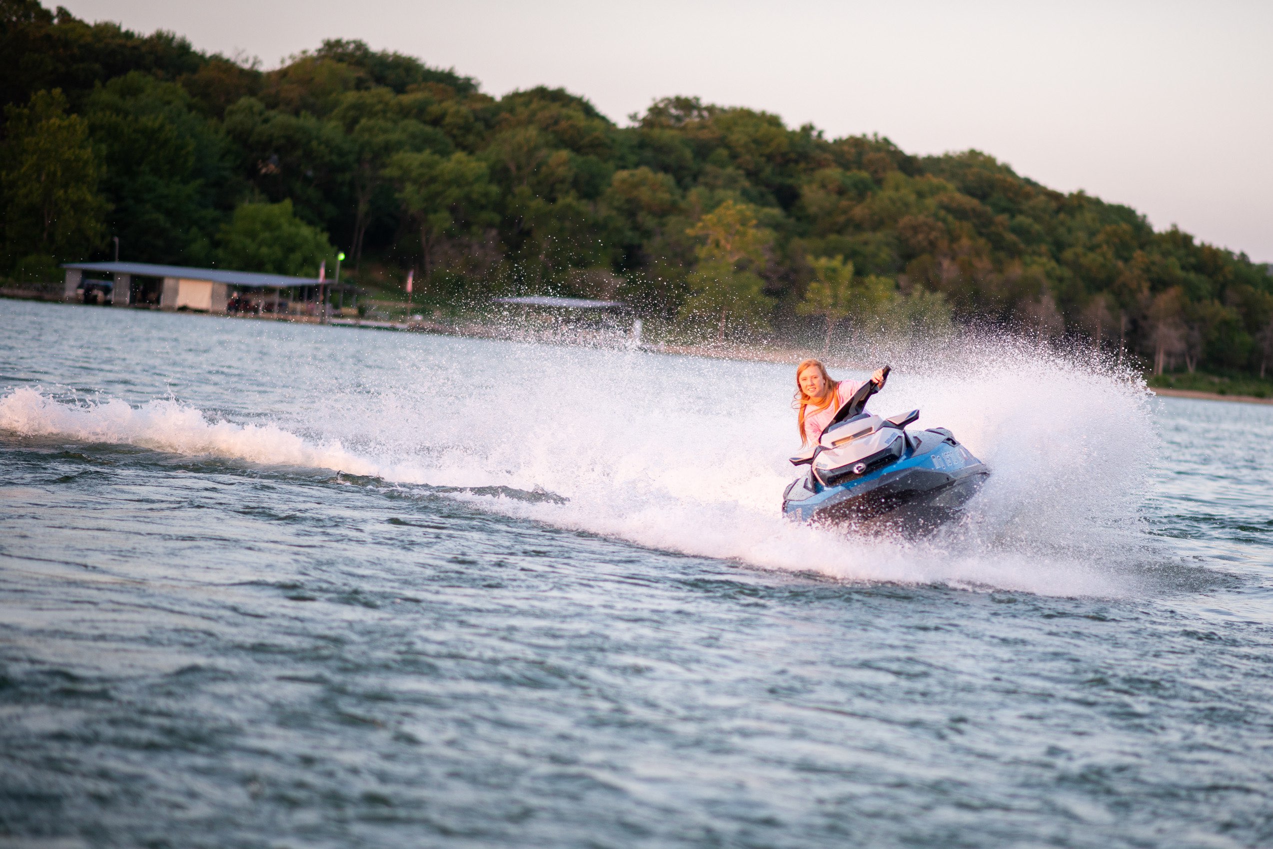 Senior girl riding a jet ski at sunset on Tablerock Lake.