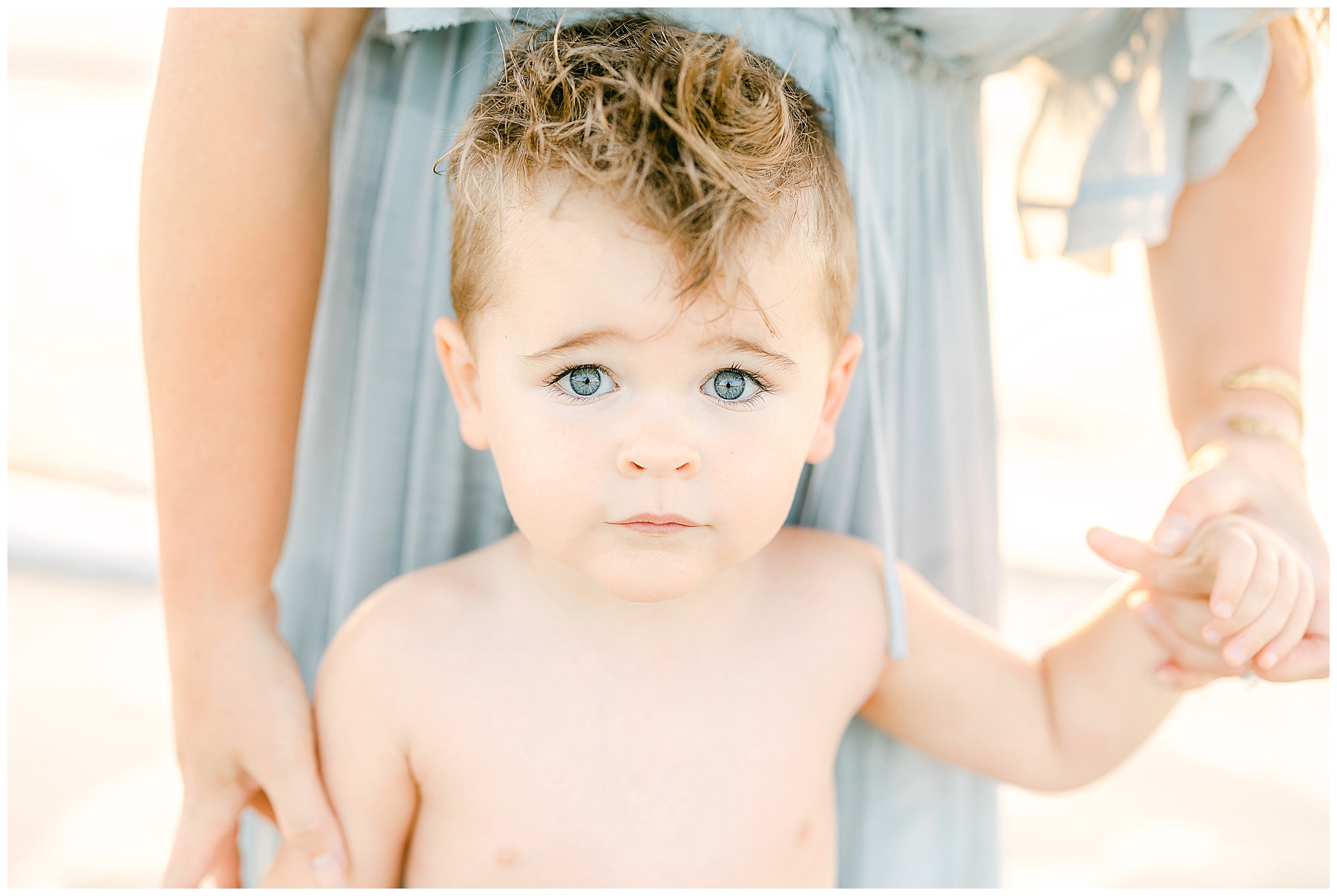 little boy with green eyes on the beach at sunrise