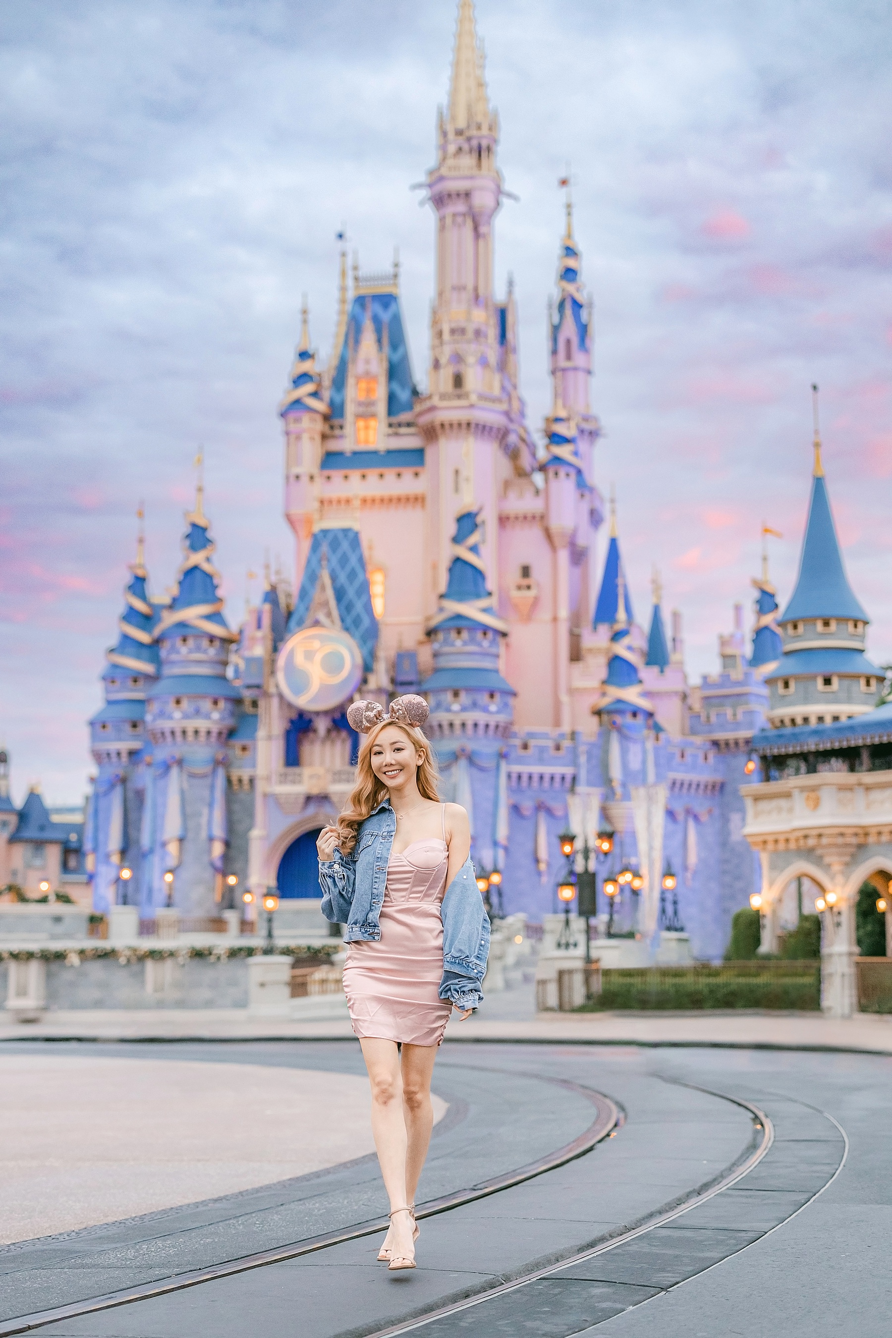 woman in pink dress and heels standing in front of Cinderella's Castle at Walt Disney World Magic Kingdom Orlando Florida