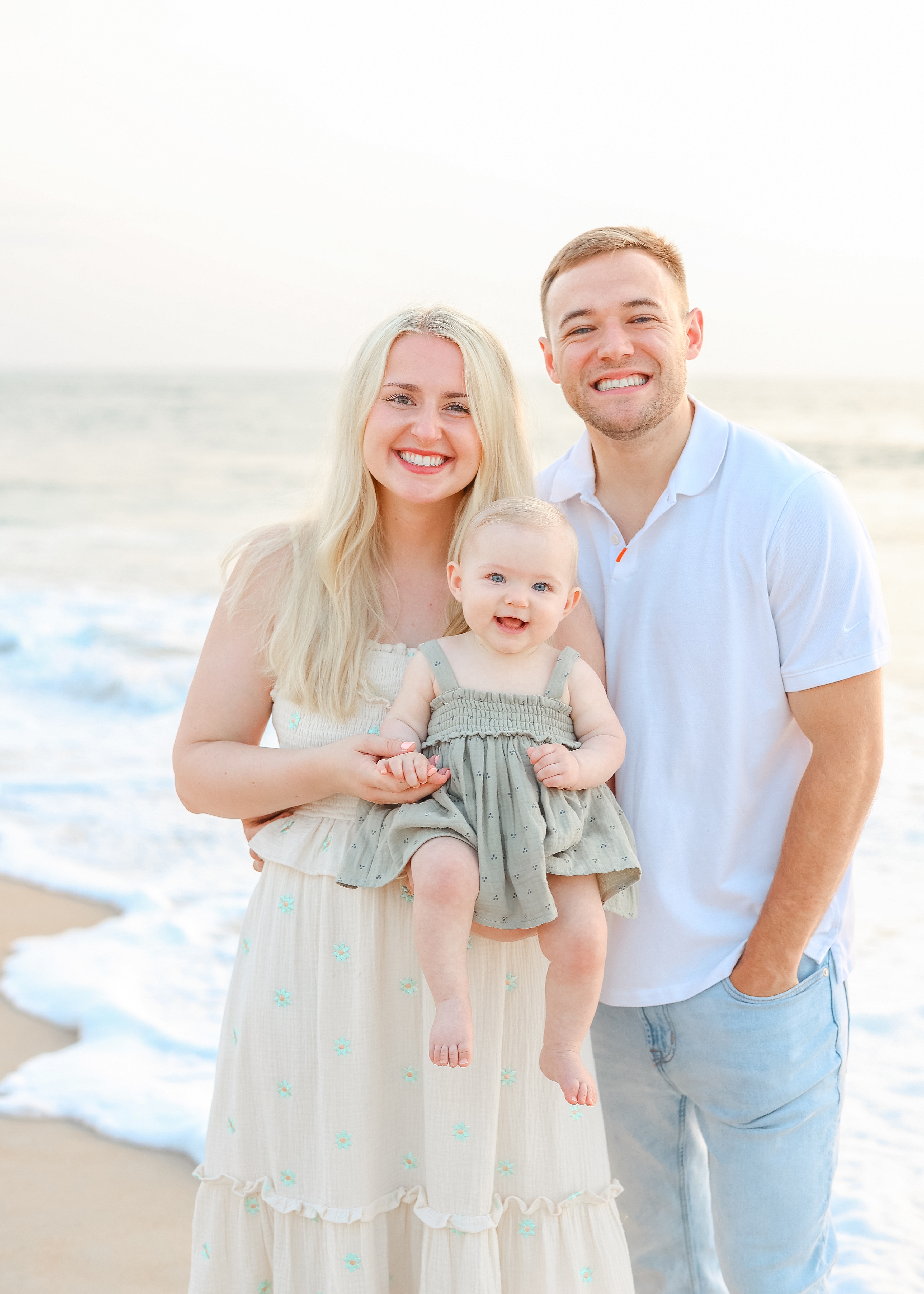 family with baby girl in sage green dress on the beach at sunrise in Saint Augustine Florida