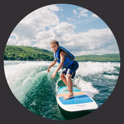 Young boy on wakeboard in Maine lake