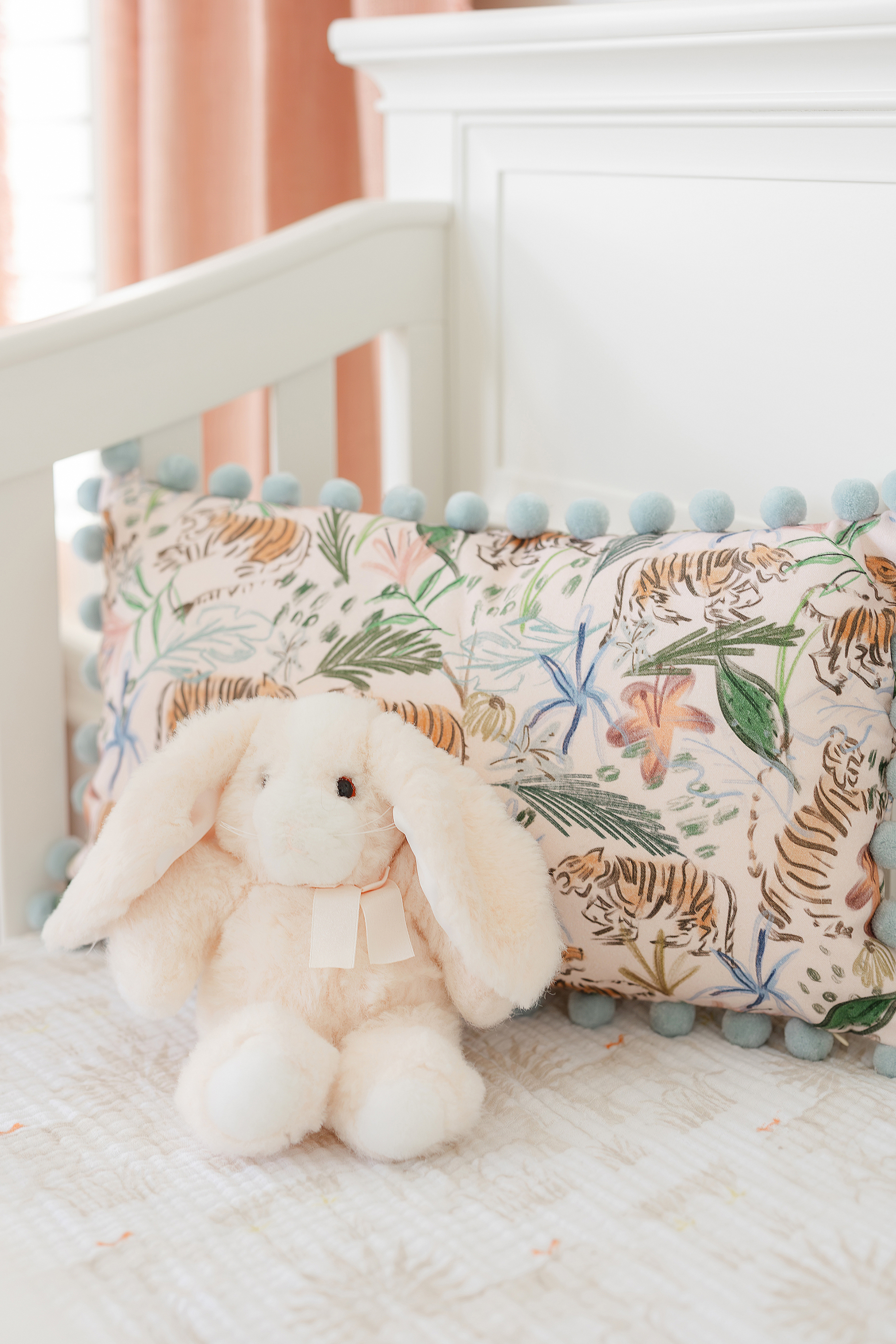 A detail photograph of a pink bunny on a chair in a designer newborn baby girl nursery.