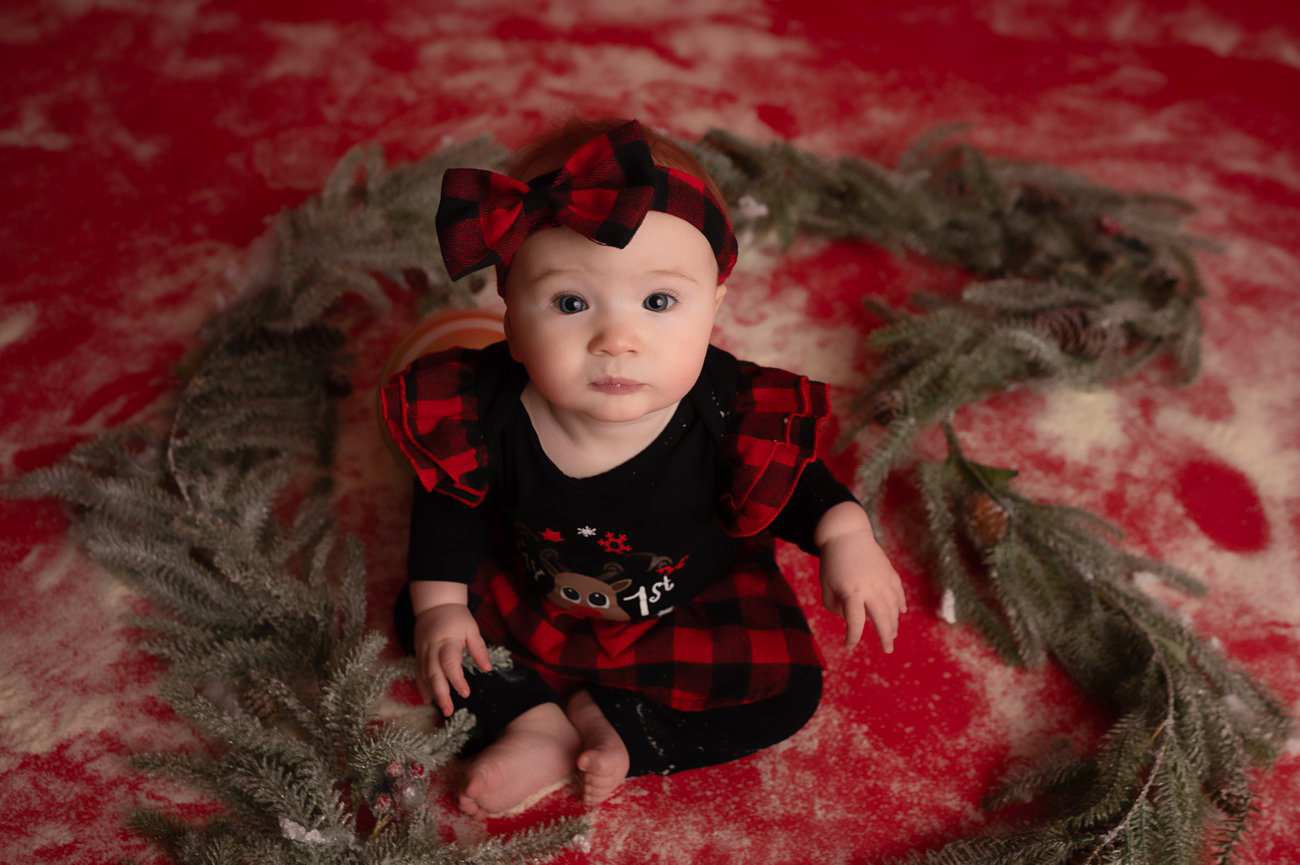 Sitter Session, baby surrounded by evergreen