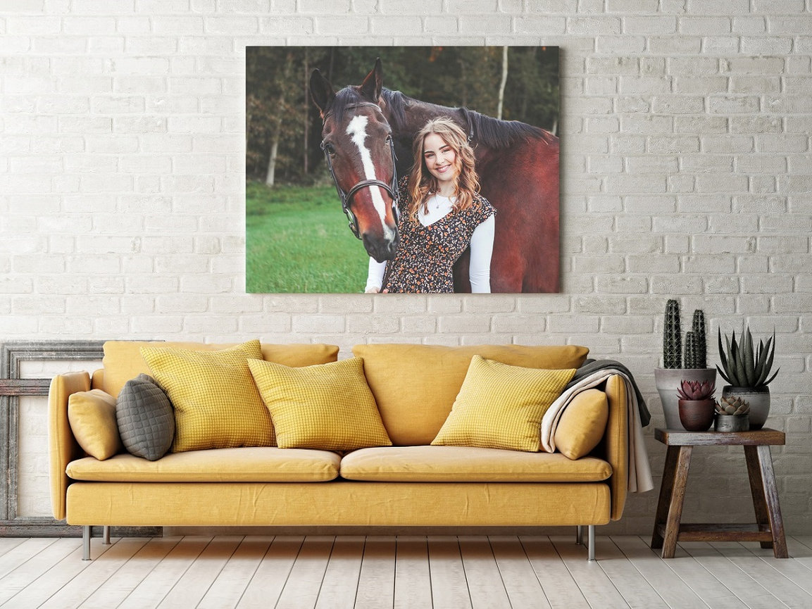 High school senior girl and horse portrait on wall above couch