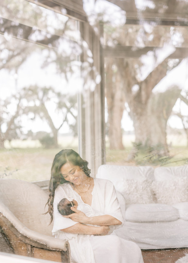 Mother holding newborn baby in soft window light – Jacksonville photographer