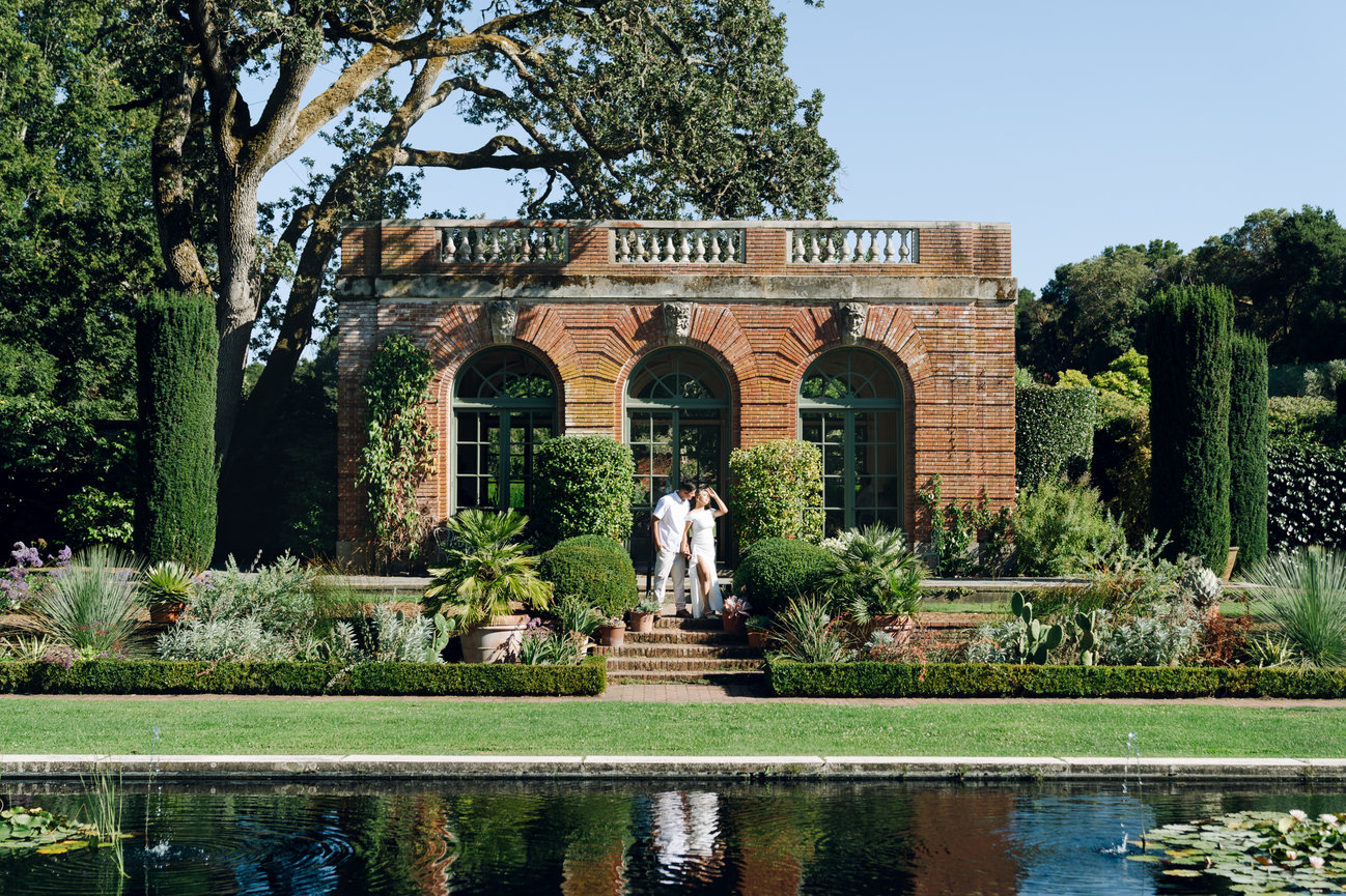 Couple standing by a luxurious villa with garden