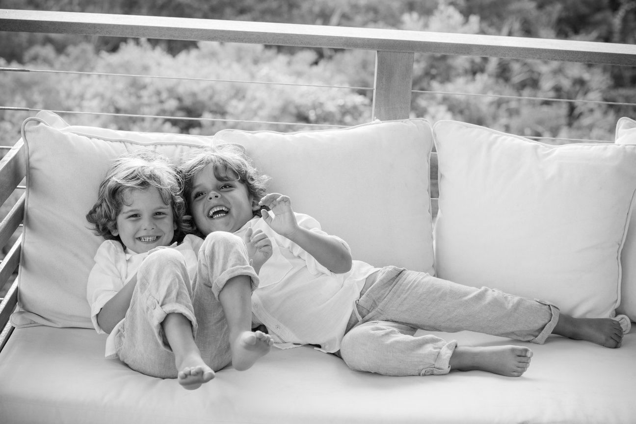 Two children lounging on a sofa