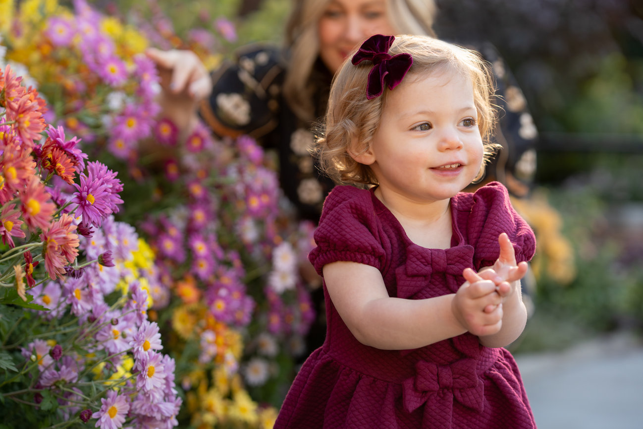 Toddler clapping near flowers