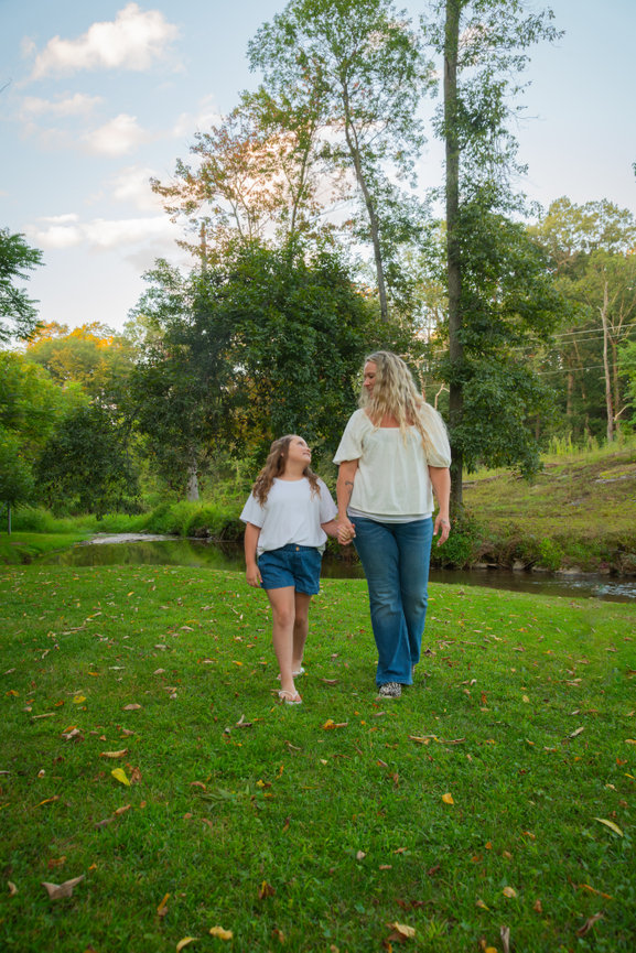 Mother and daughter walking in a grassy area