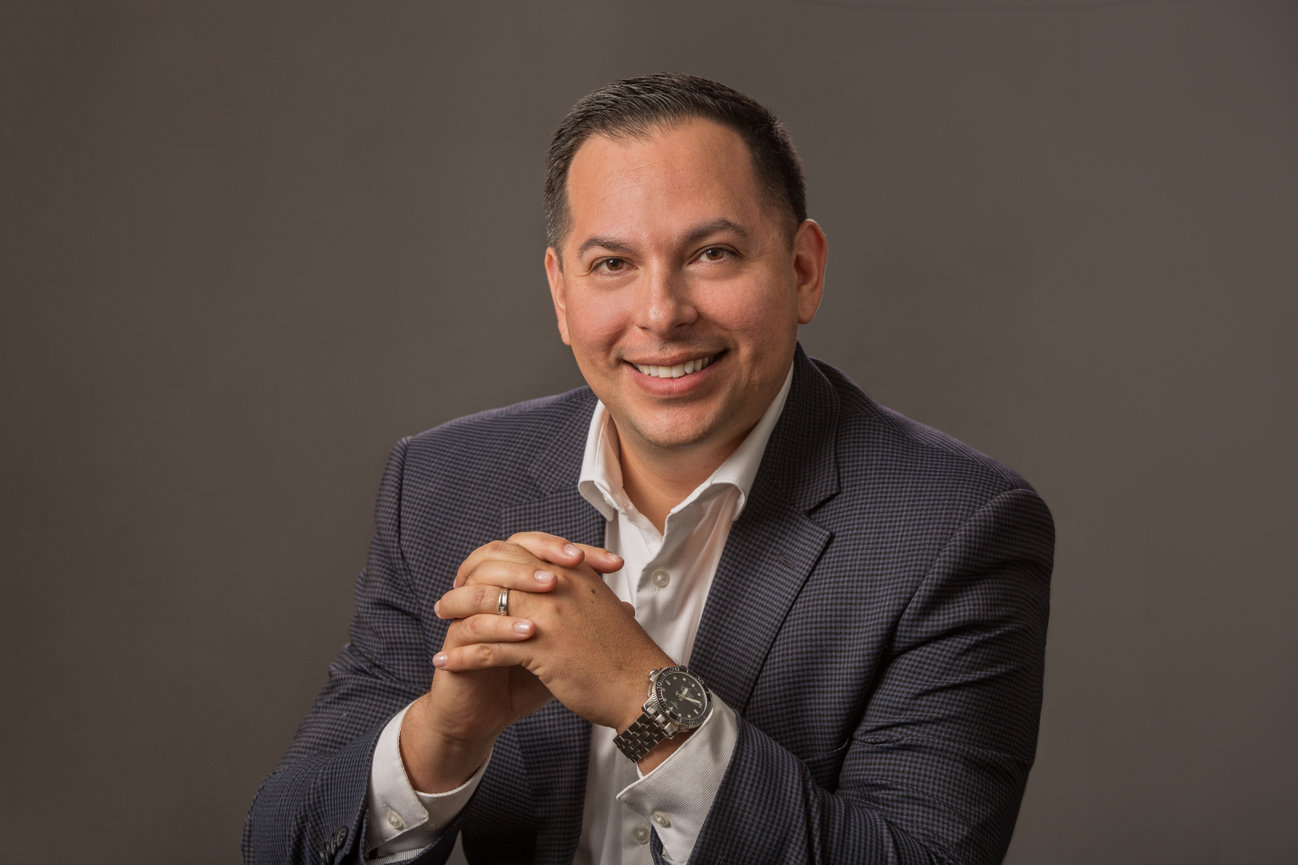 Man with folded hands showing watch