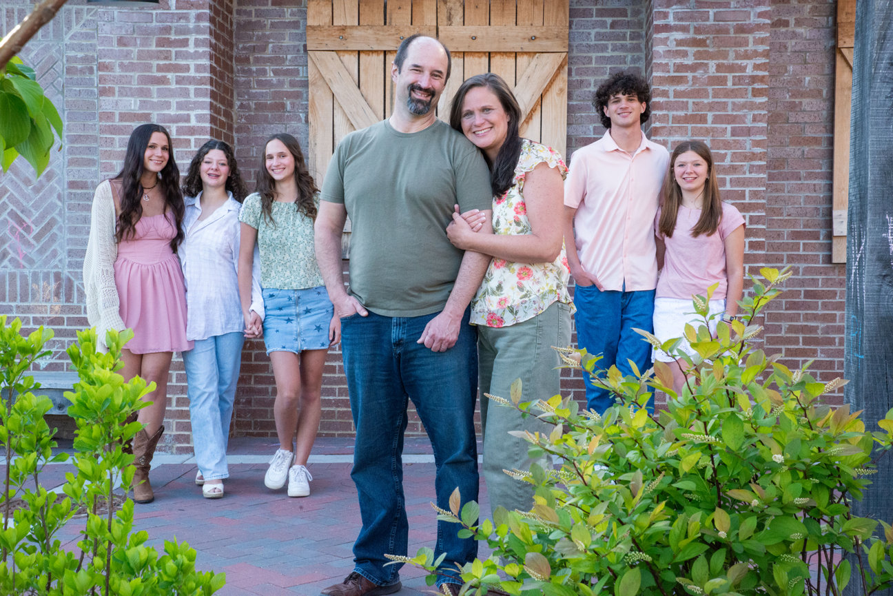 Family walking together in a courtyard with brick walls.