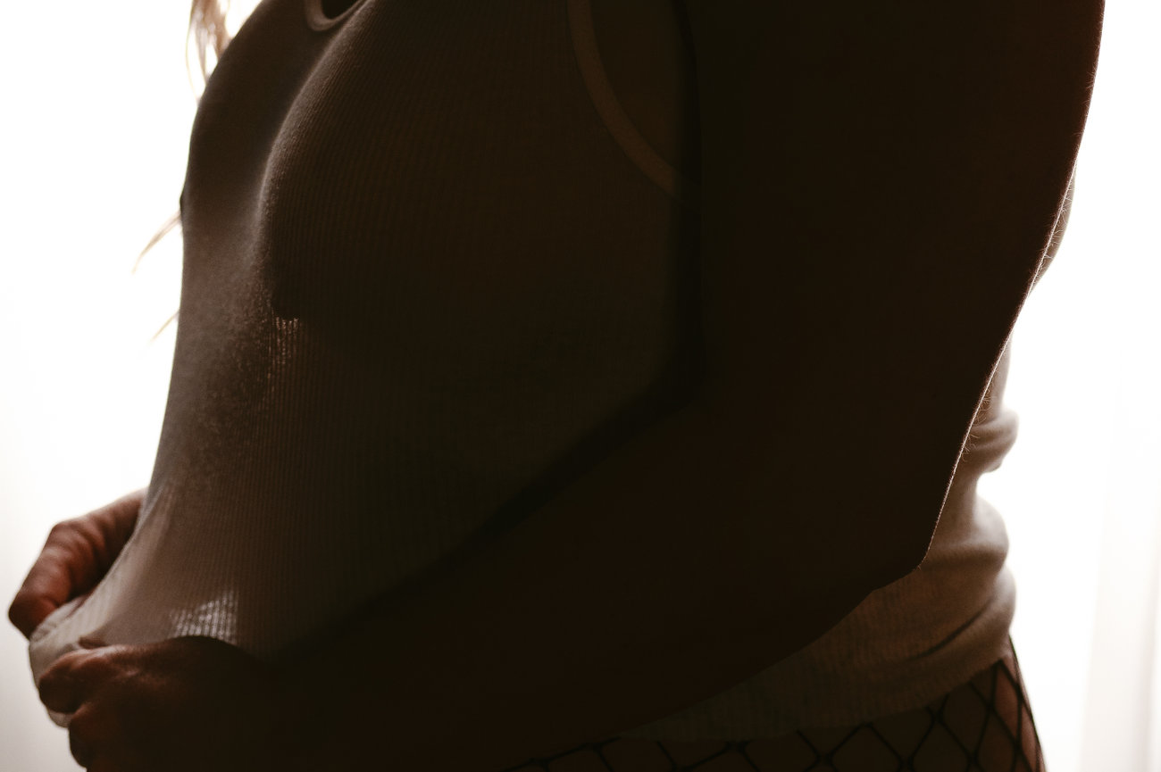 Close-up of a person in a wet top against a bright backlit background