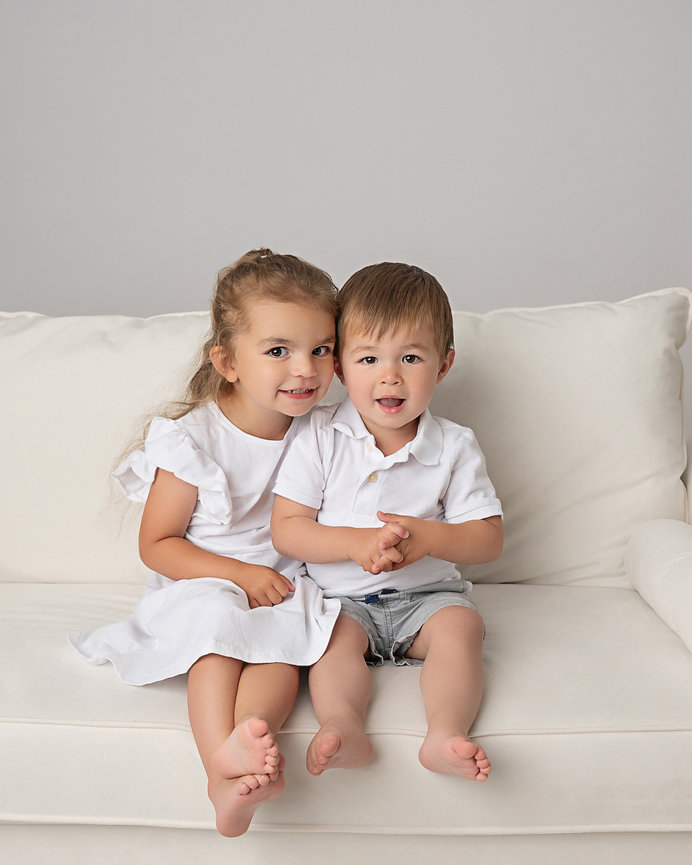 Red Bank siblings on white couch during photography session