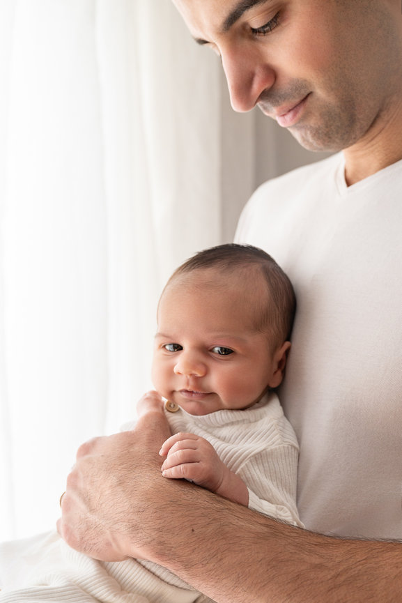 Candid moment of baby awake, head on parent chest