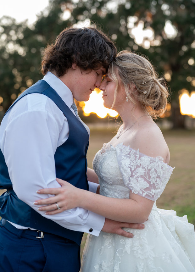 Bride and groom embracing closely in a soft wedding portrait.