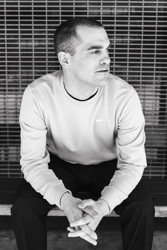 A man sitting on a bench in black and white lighting in the Bay Area