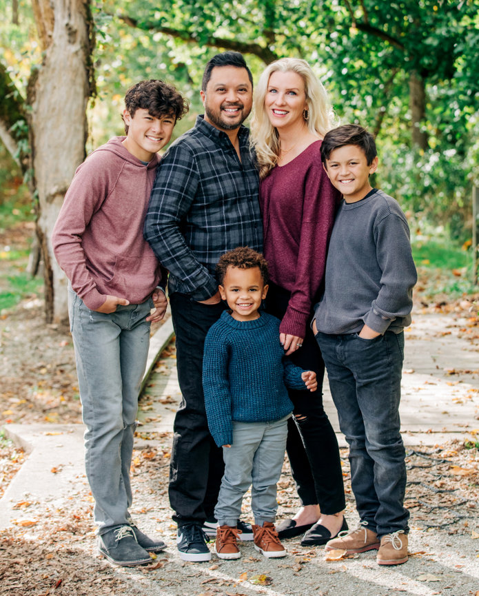 A mixed race beautiful family of five smiles at the camera for a relaxed family portrait in Fishers Indiana on a fall day.