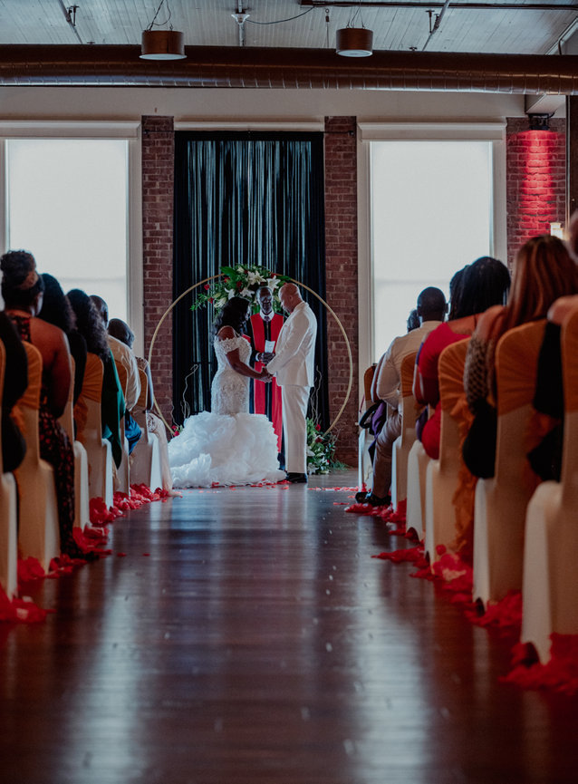 wedding event photography bride and groom at the altar red petals priest officiating johayesimages