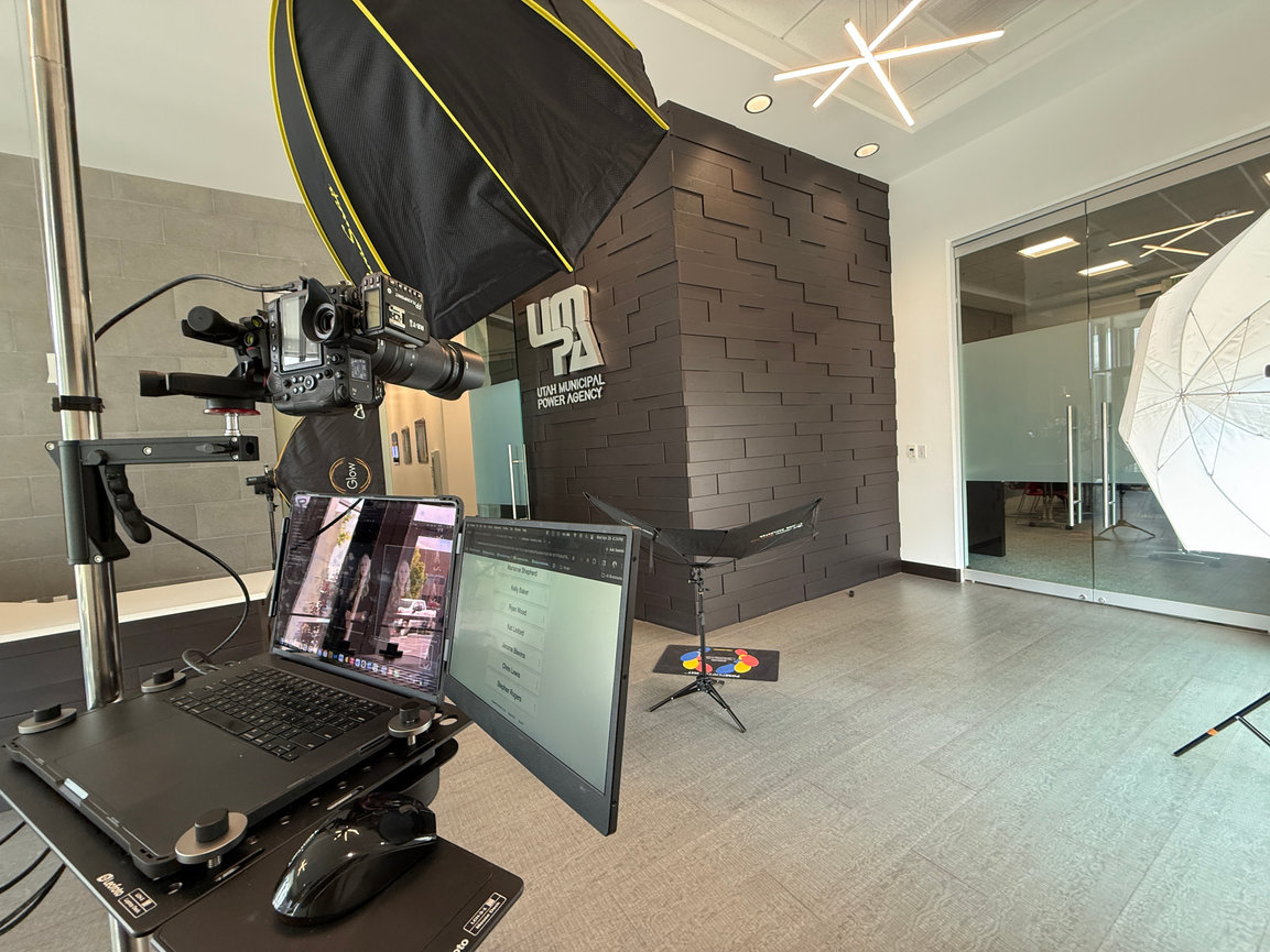 Photography studio setup with camera, lights, laptop, and monitors in an office lobby