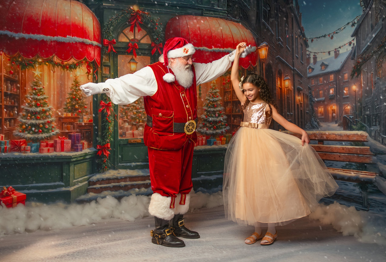 Santa dancing with a young girl in a snowy Christmas street scene during an Annapolis Christmas photography session