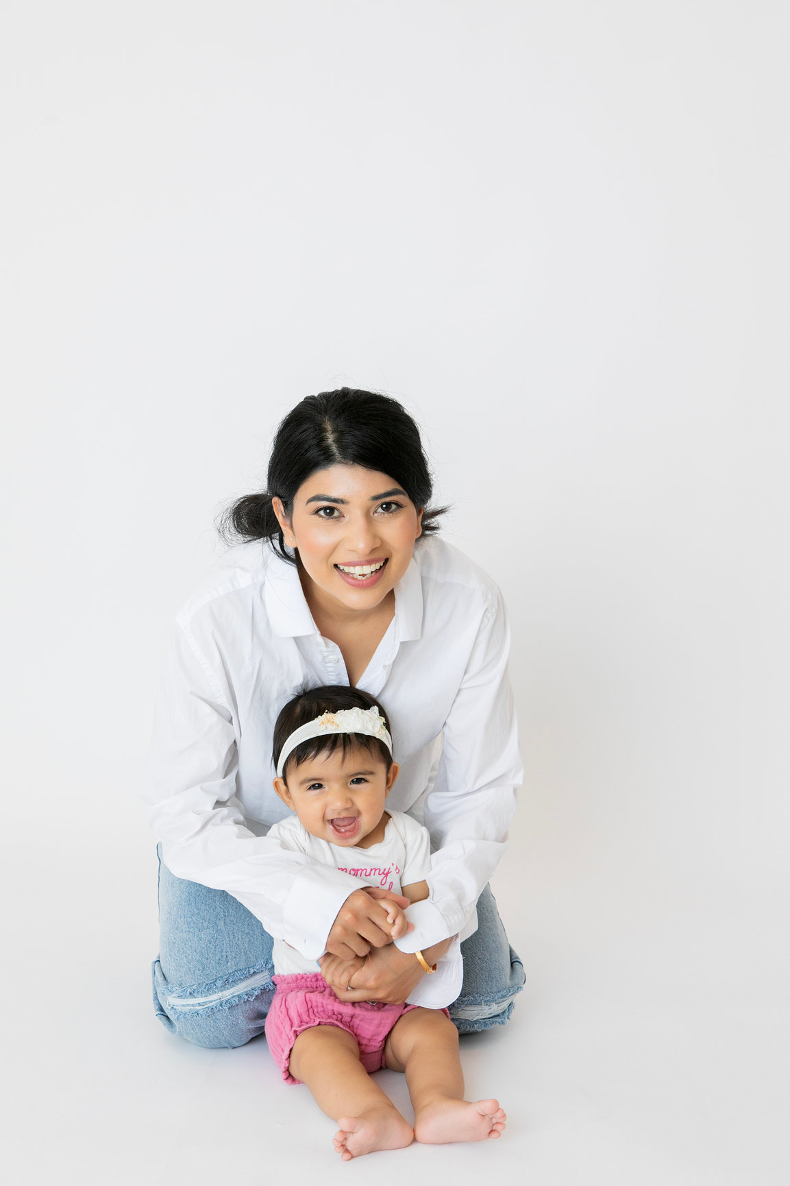 Older sibling sitting with the baby in the studio