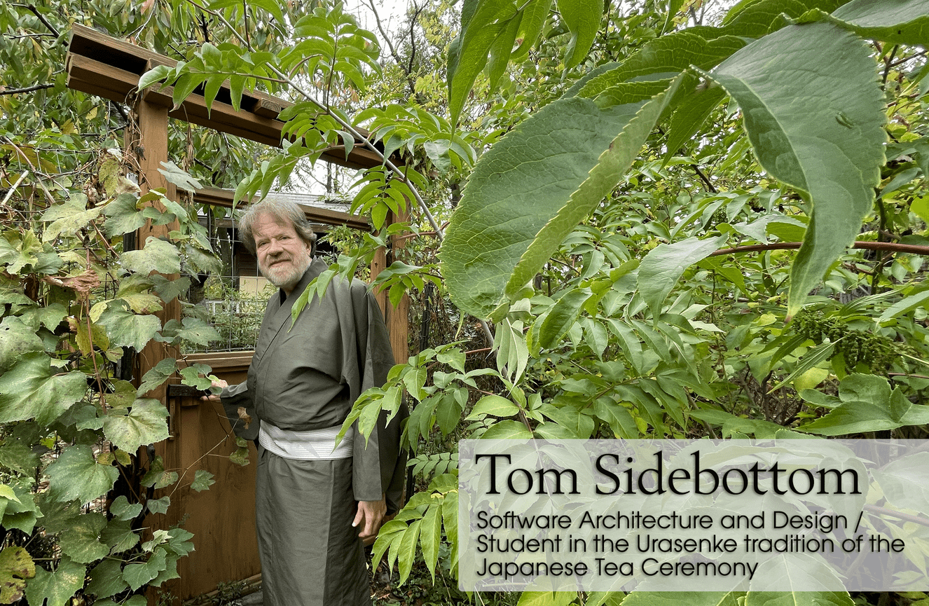 A photo of a man wearing a Japanese kimono standing outside his custom buildttea house.