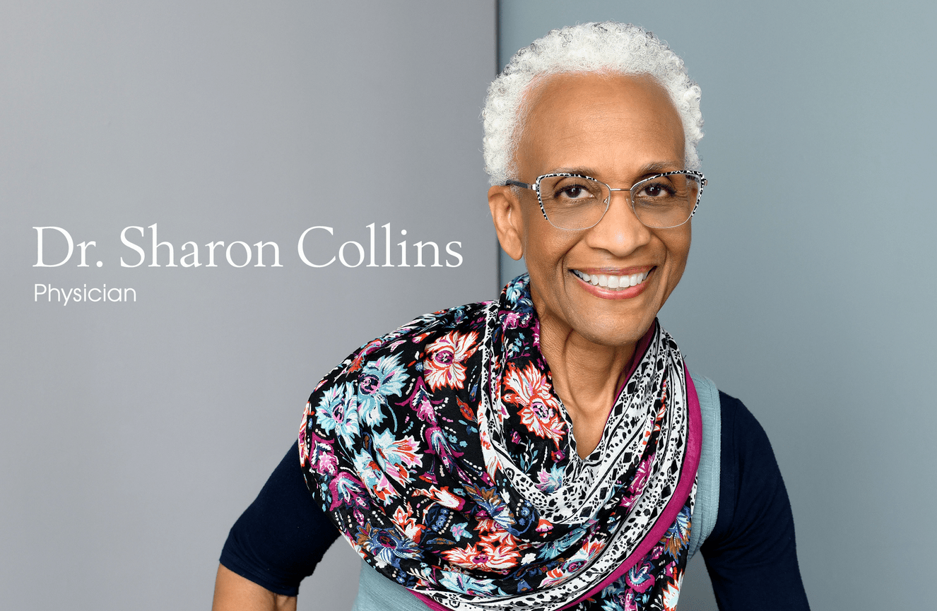 A cheerful portrait of Dr. Collins who is wearing a colorful blue, navy, and pink neck scarf at Kliks Photography.