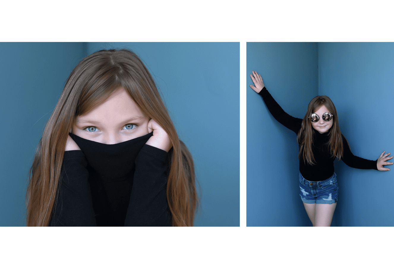 A young girl pulling her black turtle tank above her face.