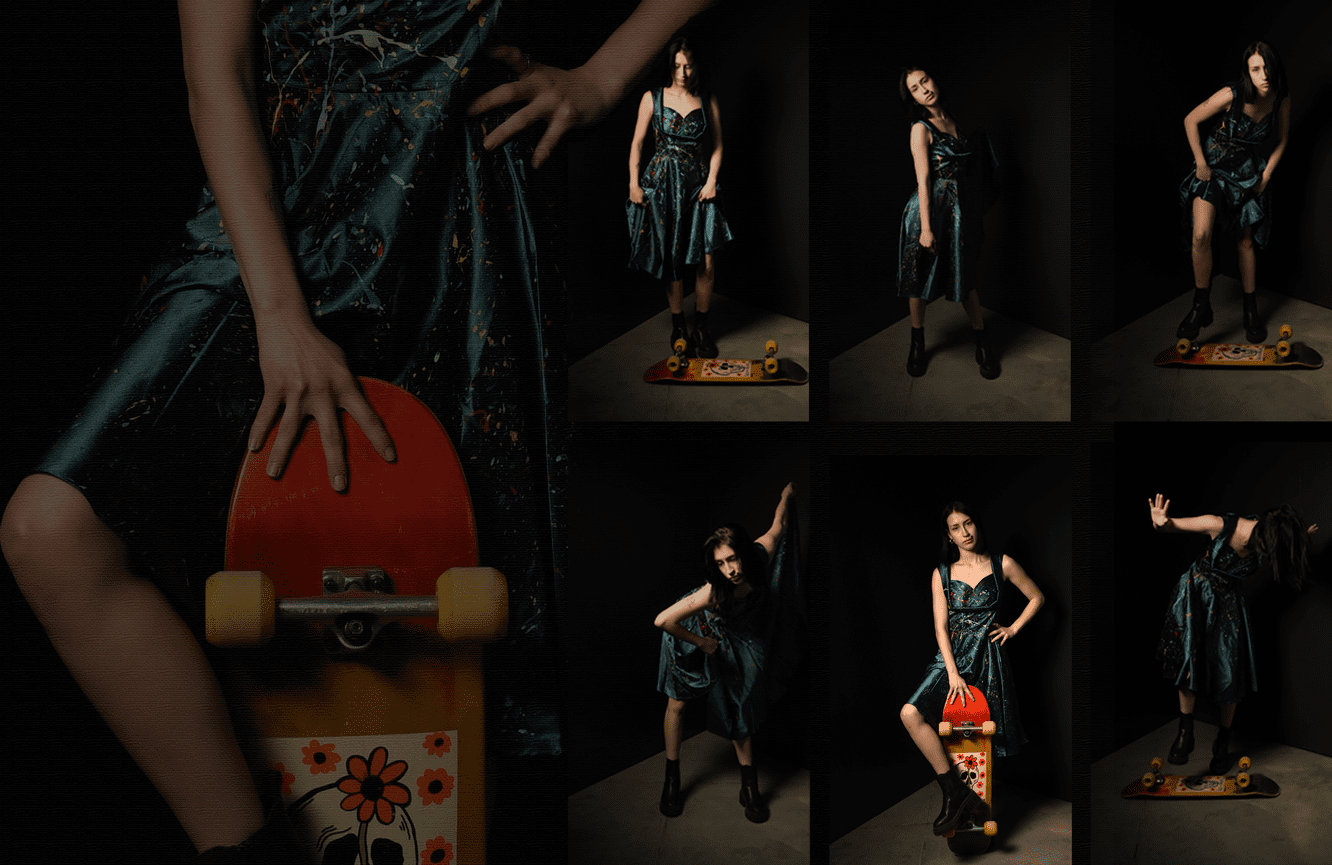 A young woman in a teal silk dress with her orange artistically designed skateboard.