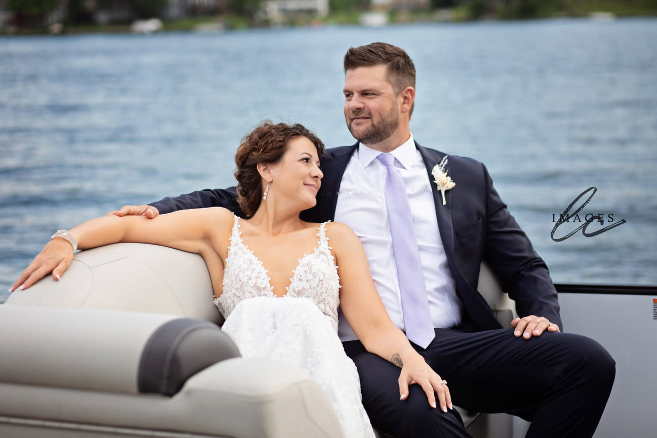Bride and groom sitting together on a couch by the lake