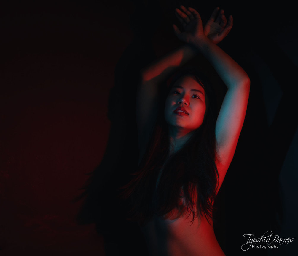 Confident woman posing with use of dramatic color lighting