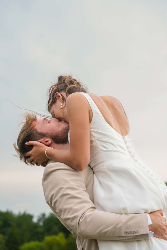 Groom lifting the bride in an outdoor portrait.