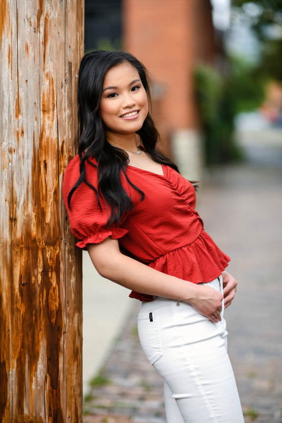 High school senior girl standing next to a light post during her portrait session in German Village, Columbus, Ohio